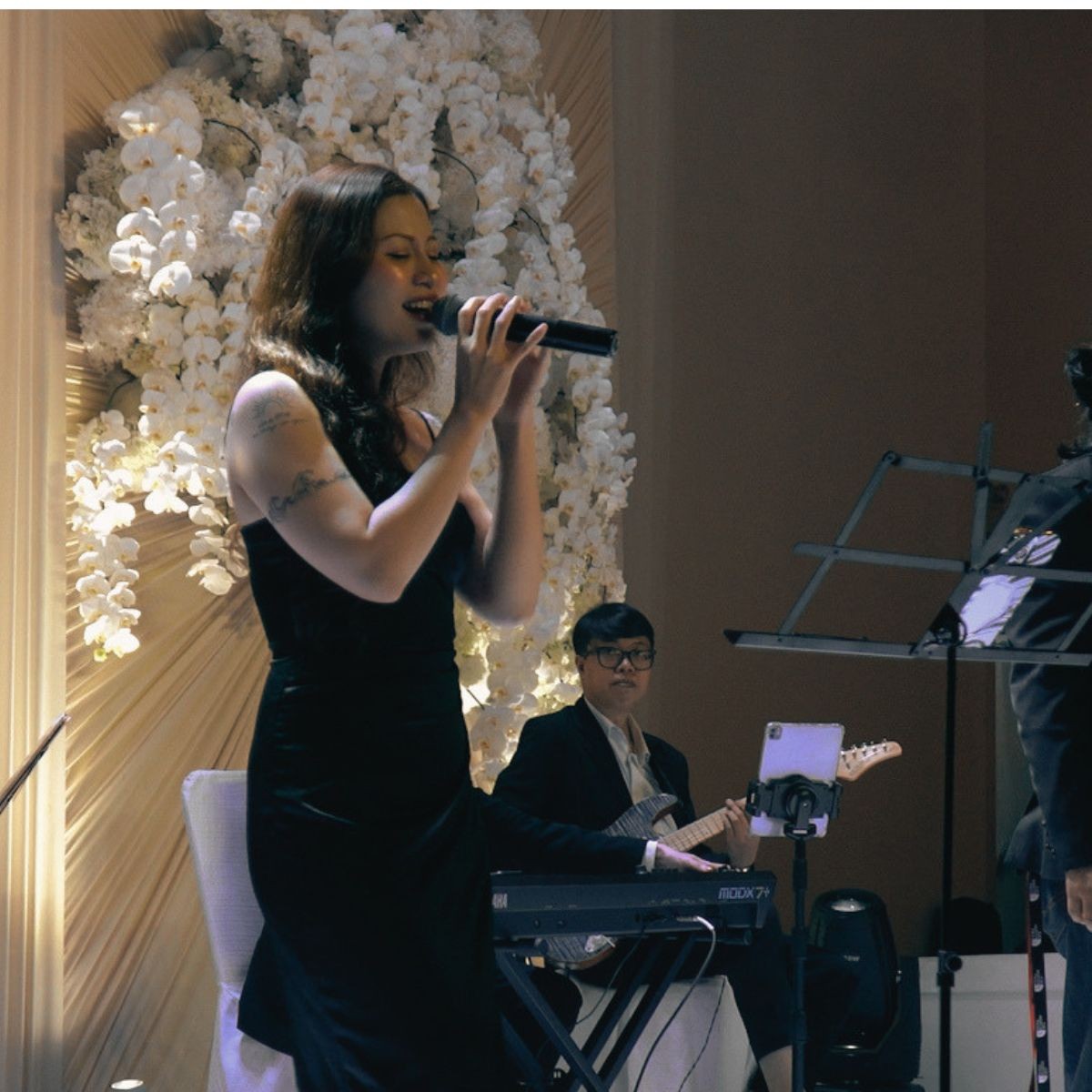 Modern live wedding band performing during an evening ballroom reception