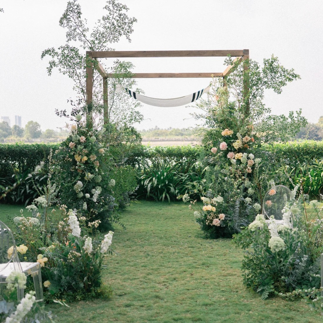Outdoor wedding ceremony setting surrounded by greenery and flowers